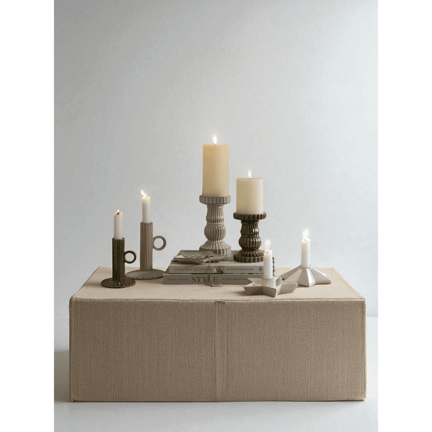 Alora Olive Ceramic Pillar Candle Holder displayed among various candles and decor, showcasing modern design with Mediterranean charm.