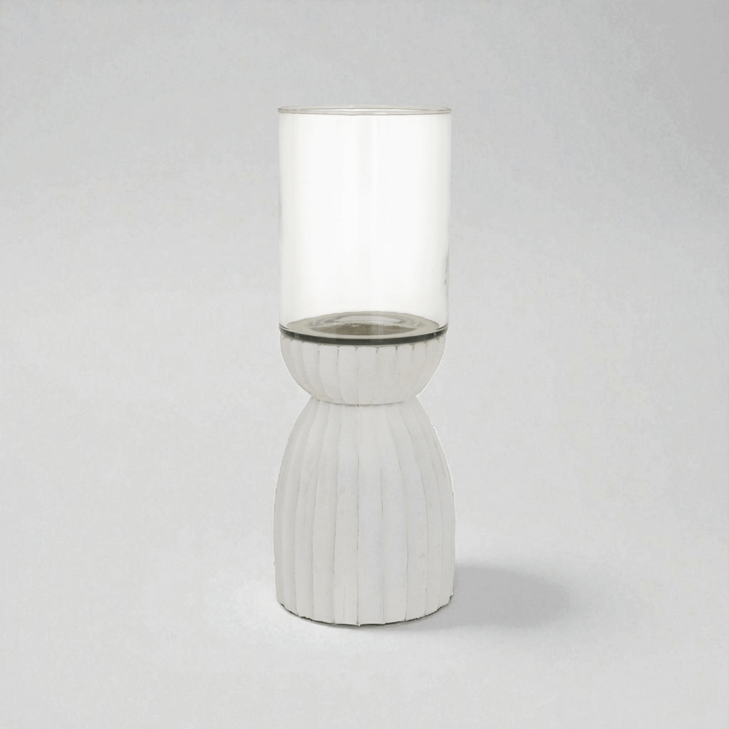 White carved hurricane lantern with glass and wood design, perfect for ambient lighting indoors and outdoors.
