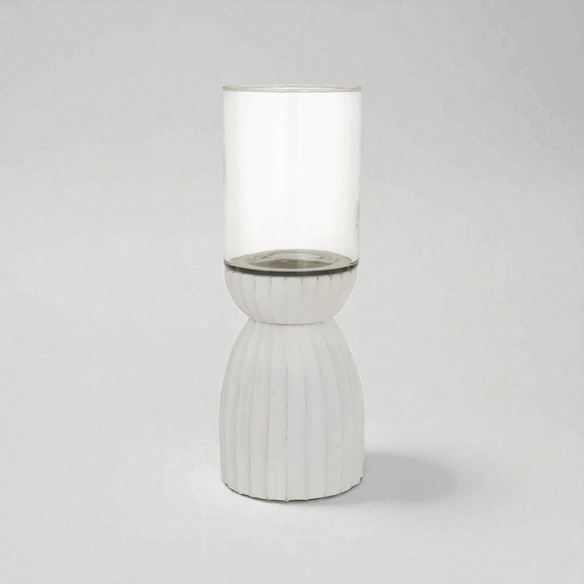 White carved hurricane lantern with glass and wood design, perfect for ambient lighting indoors and outdoors.